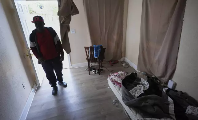 Haitian immigrant Idaneau Mintor, a meat plant worker, stands in the doorway of his one-bedroom apartment he shares with a fellow Haitian, Tuesday, April 15, 2025, in Dumas, Texas. (AP Photo/Eric Gay)