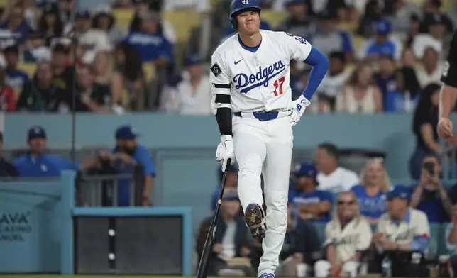 Los Angeles Dodgers' Shohei Ohtani winces after being hit with his own foul ball during the fourth inning of a baseball game against the Arizona Diamondbacks, Wednesday, May 21, 2025, in Los Angeles. (AP Photo/Mark J. Terrill)