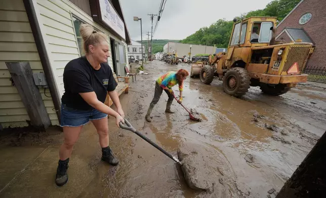 From left, Ashley Rishel from the Allegany County 911 and Lesley Moran help clean up Main Street after flooding on Wednesday, May 14, 2025 in Westernport, Md. (AP Photo/Gene J. Puskar)