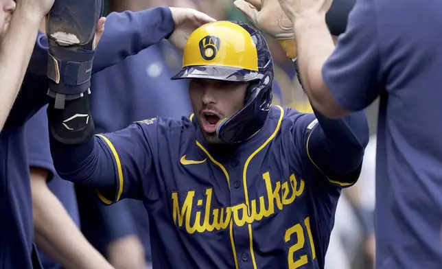Milwaukee Brewers' Caleb Durbin celebrates in the dugout after scoring during the eighth inning of a baseball game against the Pittsburgh Pirates, Sunday, May 25, 2025, in Pittsburgh. (AP Photo/Matt Freed)