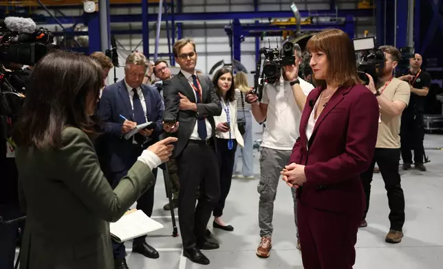Britain's Chancellor of the Exchequer Rachel Reeves, right, speaks with the media at the Rolls-Royce factory in Derby, England following the announcement from the Office for National Statistics that the U.K. economy grew by 0.7% between January and March, Thursday, May 15, 2025. (Darren Staples/PA via AP)