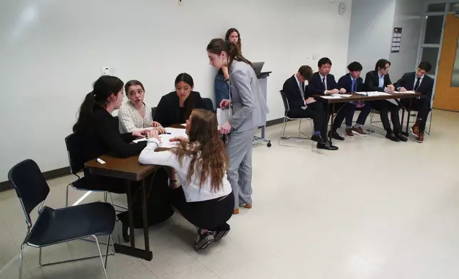Students from Atlanta's Midtown High School, foreground, confer during a quarterfinal round at the National High School Ethics Bowl in Chapel Hill, N.C., on Sunday, April 13, 2025. (AP Photo/Allen G. Breed)
