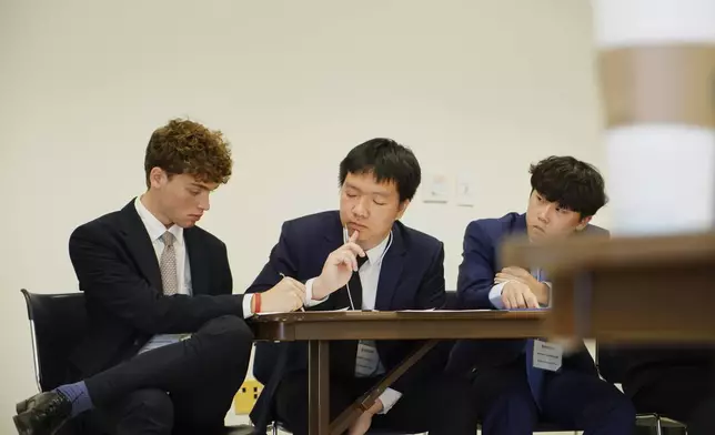 Students from the Dwight-Englewood School in New Jersey confer during a quarterfinal round of the National High School Ethics Bowl in Chapel Hill, N.C., on Sunday, April 13, 2025. (AP Photo/Allen G. Breed)