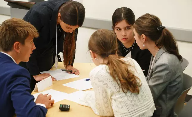 Kate Kruger, facing camera, and other students from Atlanta's Midtown High School confer during a semifinal round of the National High School Ethics Bowl in Chapel Hill, N.C., on Sunday, April 13, 2025. (AP Photo/Allen G. Breed)