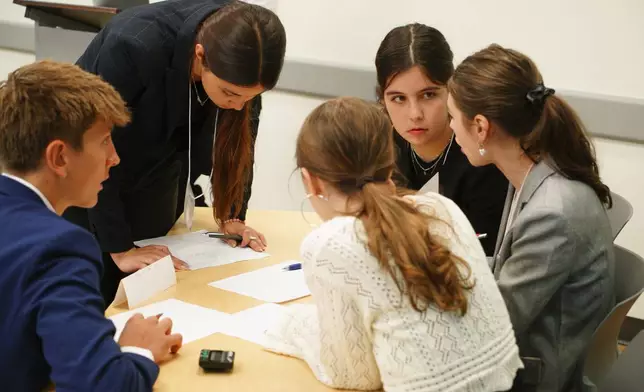 CORRECTS ID TO KRUGMAN NOT KRUGER Kate Krugman, facing camera, and other students from Atlanta's Midtown High School confer during a semifinal round of the National High School Ethics Bowl in Chapel Hill, N.C., on Sunday, April 13, 2025. (AP Photo/Allen G. Breed)