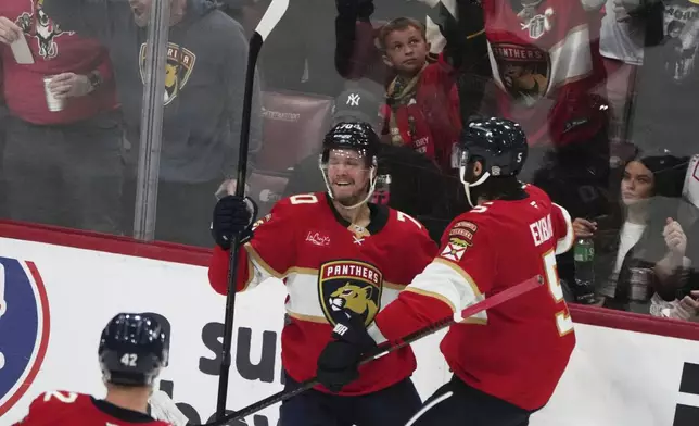 Florida Panthers center Jesper Boqvist, left, reacts after scoring a goal against the Carolina Hurricanes during the third period in Game 3 of the NHL hockey Stanley Cup Eastern Conference finals Saturday, May 24, 2025, in Sunrise, Fla. (AP Photo/Lynne Sladky)