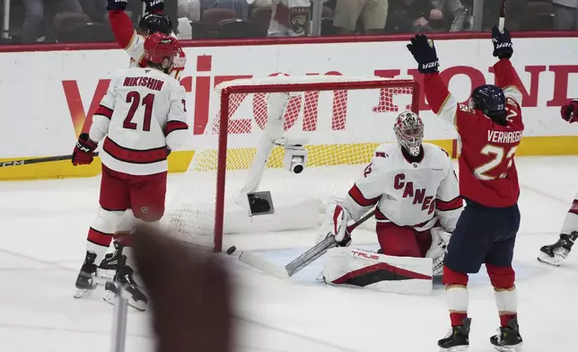 The puck gets past Carolina Hurricanes goaltender Pyotr Kochetkov, center, on a goal scored by Florida Panthers' Aleksander Barkov during the third period in Game 3 of the NHL hockey Stanley Cup Eastern Conference finals Saturday, May 24, 2025, in Sunrise, Fla. (AP Photo/Lynne Sladky)