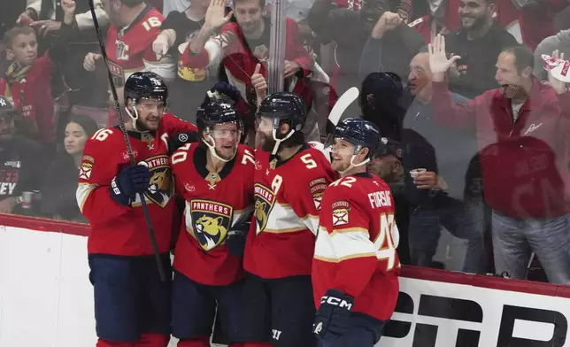 Florida Panthers center Jesper Boqvist (70) celebrates with Aleksander Barkov (16), Aaron Ekblad (5) and Gustav Forsling (42) after scoring a goal against the Carolina Hurricanes during the third period in Game 3 of the NHL hockey Stanley Cup Eastern Conference finals Saturday, May 24, 2025, in Sunrise, Fla. (AP Photo/Lynne Sladky)