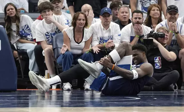 Minnesota Timberwolves guard Anthony Edwards (5) grabs his leg during the first half of Game 2 of an NBA basketball second-round playoff series against the Golden State Warriors, Thursday, May 8, 2025, in Minneapolis. (AP Photo/Abbie Parr)