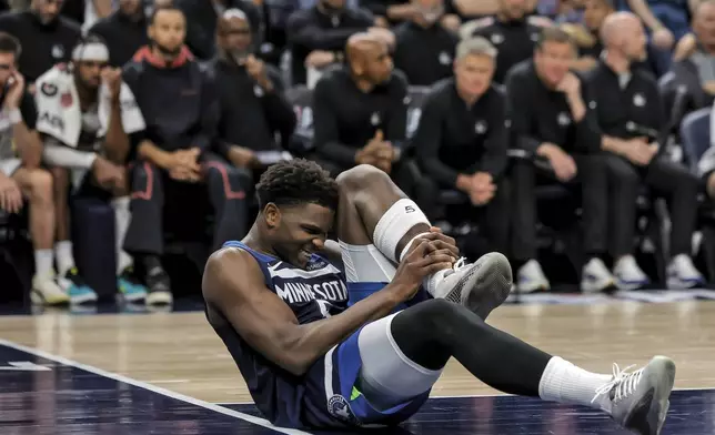 Minnesota Timberwolves guard Anthony Edwards (5) grabs his leg on the court during the first half of Game 2 of an NBA basketball second-round playoff series against the Golden State Warriors, Thursday, May 8, 2025, in Minneapolis. (Carlos Avila Gonzalez/San Francisco Chronicle via AP)