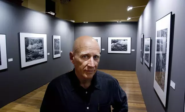 FILE - Brazilian photographer Sebastiao Salgado poses for a photo at his exhibit in the Artes e Oficios Museum of Belo Horizonte, Brazil, Oct. 26, 2006. Salgado, known for his long-term projects and images of nature and humanity, died at age 81, the Instituto Terra confirmed on Friday, May 23, 2025. (AP Photo/Eugenio Savio)