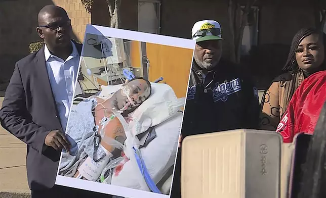 FILE - In this photo provided by WREG, Tyre Nichols' stepfather Rodney Wells, center, stands next to a photo of Nichols in the hospital after his arrest, during a protest in Memphis, Tenn., Jan. 14, 2023. (Jordan James/WREG via AP)