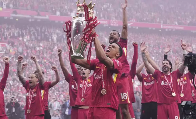 Liverpool's Trent Alexander-Arnold holds the winner's trophy as he celebrates with teammates after the English Premier League soccer match between Liverpool and Crystal Palace at the Anfield stadium in Liverpool, England, Sunday, May 25, 2025. (AP Photo/Jon Super)