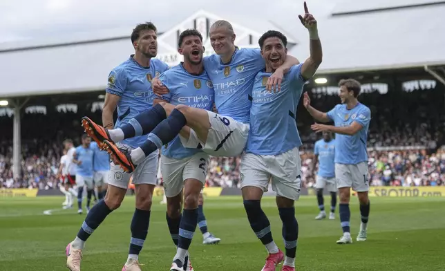 Manchester City players celebrate after Manchester City's Erling Haaland, centre, scored his side's second goal during the English Premier League soccer match between Fulham and Manchester City at Craven Cottage, London, Sunday, May 25, 2025. (AP Photo/Dave Shopland)