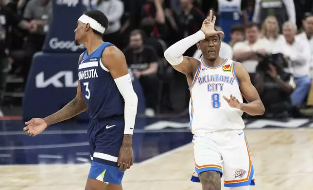 Oklahoma City Thunder forward Jalen Williams (8) gestures after making a 3-point basket next to Minnesota Timberwolves forward Jaden McDaniels (3) during the second half of Game 4 of the Western Conference finals of the NBA basketball playoffs Monday, May 26, 2025, in Minneapolis. (AP Photo/Abbie Parr)