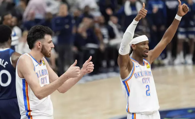 Oklahoma City Thunder forward Chet Holmgren, left, and guard Shai Gilgeous-Alexander (2) gesture during the first half of Game 4 of the Western Conference finals of the NBA basketball playoffs against the Minnesota Timberwolves Monday, May 26, 2025, in Minneapolis. (AP Photo/Abbie Parr)