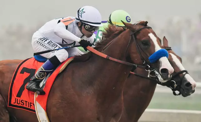 FILE - Justify (7), with Mike Smith aboard, edges ahead of Good Magic, with Jose Ortiz atop, down the stretch to win the 143rd Preakness Stakes horse race at Pimlico race track, Saturday, May 19, 2018, in Baltimore. Justify won the race. (AP Photo/Tom Horan, File)