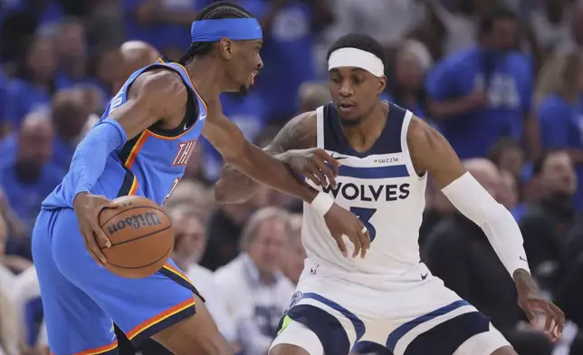 Oklahoma City Thunder guard Shai Gilgeous-Alexander (2) works toward the basket as Minnesota Timberwolves forward Jaden McDaniels (3) defends during the first half of Game 5 of the Western Conference finals of the NBA basketball playoffs, Wednesday, May 28, 2025, in Oklahoma City. (AP Photo/Nate Billings)