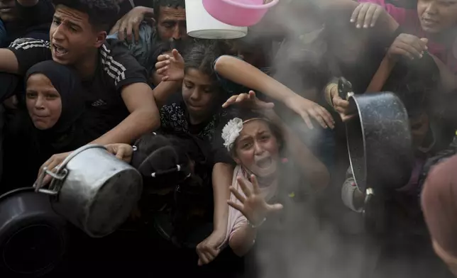 FILE.- A Palestinian girl struggles as she and others try to get donated food at a distribution center in Beit Lahiya, northern Gaza Strip, Sunday, March 16, 2025. (AP Photo/Abdel Kareem Hana,File)