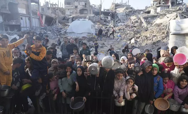 FILE.- Palestinians wait for donated food at a distribution center in Beit Lahiya, northern Gaza Strip, Sunday, March 16, 2025. (AP Photo/Abdel Kareem Hana,File)