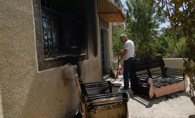 Palestinian landlord Akram Sabra, 60, inspects his house, burnt overnight by Israeli settlers in an attack that left several burnt vehicles and damaged homes, residents said, in the West Bank village of Bruqin, near Salfit, Friday, May 23, 2025. (AP Photo/Nasser Nasser)