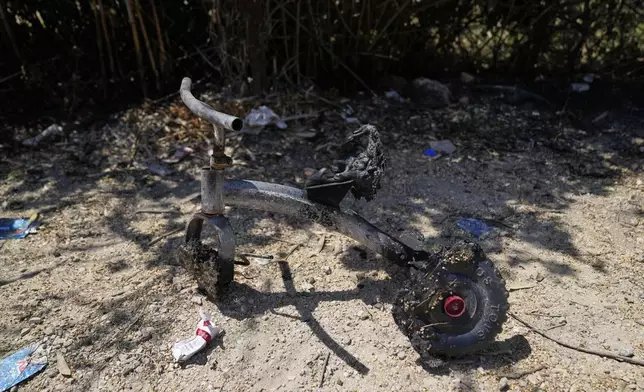 A burnt children bicycle is seen on the Palestinian properties that were under attack by Israeli settlers overnight, leaving several burnt vehicles and damaged homes, residents said, in the West Bank village of Bruqin, near Salfit, Friday, May 23, 2025. (AP Photo/Nasser Nasser)