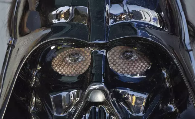 A child wearing a Darth Vader mask attends an exhibition called "Expo Yoda" in Santiago, Chile, Saturday, May 3, 2025, on the eve of May 4th, known as Star Wars Day, when fans of the franchise get to greet others with "May the Fourth be with you" in a nod to the classic movie line, "May the force be with you. (AP Photo/Matias Basualdo)