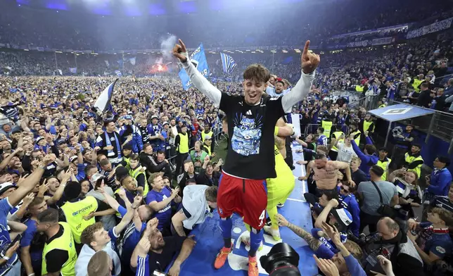 Hamburg's Otto Stange and fans celebrate promotion following a Bundesliga 2 soccer game between Hamburger SV and SSV Ulm 1846 in Hamburg, Germany, Saturday, May 10, 2025. (Christian Charisius/dpa via AP)
