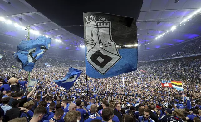 Hamburg fans storm the pitch to celebrate promotion following a Bundesliga 2 soccer game between Hamburger SV and SSV Ulm 1846 in Hamburg, Germany, Saturday, May 10, 2025. (Christian Charisius/dpa via AP)