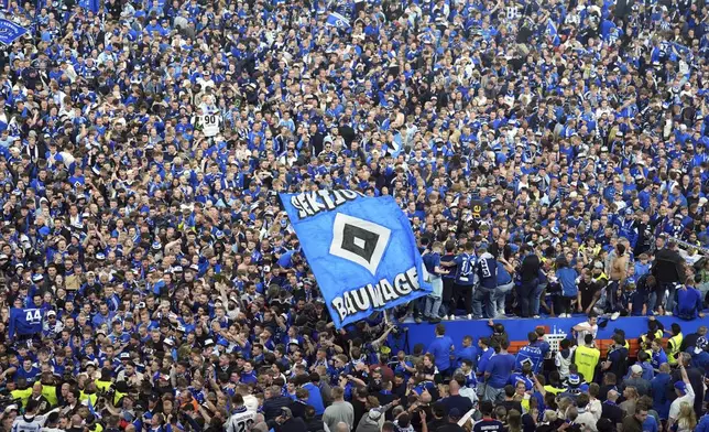 Hamburg fans storm the pitch after the match to celebrate promotion following a Bundesliga 2 soccer game between Hamburger SV and SSV Ulm 1846 in Hamburg, Germany, Saturday, May 10, 2025. (Marcus Brandt/dpa via AP)