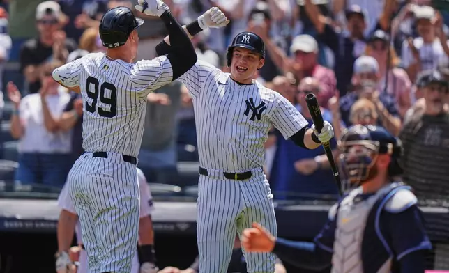 New York Yankees' Ben Rice, center, celebrates with Aaron Judge, left, after Judge hit a home run during the first inning of a baseball game against the Tampa Bay Rays Saturday, May 3, 2025, in New York. (AP Photo/Frank Franklin II)