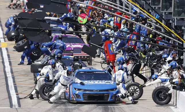 Kyle Larson, front, and other drivers stop on pit road at the end of the first stage during a NASCAR Cup Series auto race at Kansas Speedway in Kansas City, Kan., Sunday, May 11, 2025. (AP Photo/Colin E. Braley)