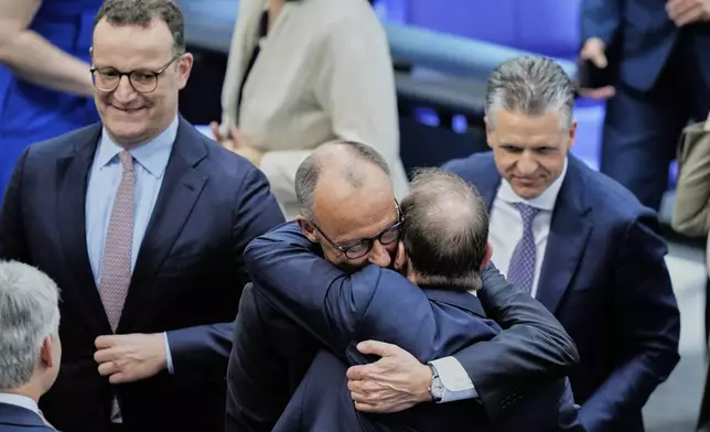 Leader of the Christian Democrats Friedrich Merz hugs Alexander Dobrindt from the CSU after being elected new chancellor at the German federal parliament, Bundestag, at the Reichstag building in Berlin, Germany, Tuesday, May 6, 2025. (AP Photo/Ebrahim Noroozi)