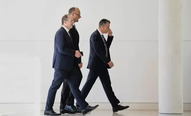 Leader of the Christian Democrats Friedrich Merz, center, Alexander Dobrindt of the Christian Social Union left, and CDU faction leader Thorsten Frei, right, are pictured after Metz fell short of votes need to be chancellor in first round vote at the German federal parliament, Bundestag, at the Reichstag building in Berlin, Germany, Tuesday, May 6, 2025. (AP Photo/Ebrahim Noroozi)