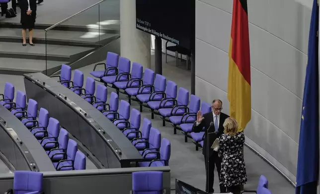 Friedrich Merz takes the oath of office in front of Parliament President Julia Kloeckner after being elected new Chancellor at the German federal parliament, Bundestag, at the Reichstag building in Berlin, Germany, Tuesday, May 6, 2025. (AP Photo/Markus Schreiber)