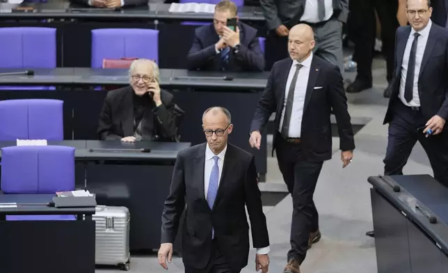 Friedrich Merz walks in the plenary after he failed to be elected new chancellor in the first voting process at the German federal parliament, Bundestag, at the Reichstag building in Berlin, Tuesday, May 6, 2025. (AP Photo/Markus Schreiber)