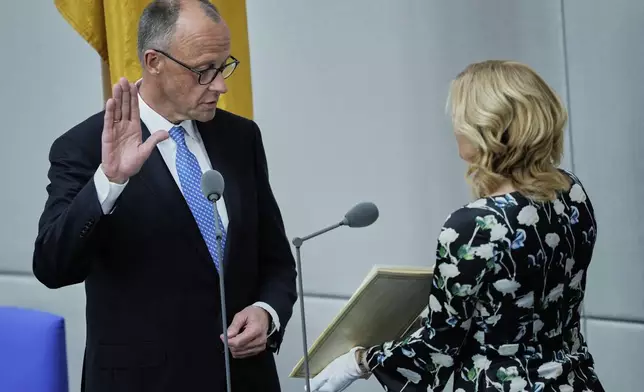 Friedrich Merz takes the oath of office in front of Parliament President Julia Kloeckner after being elected new Chancellor at the German federal parliament, Bundestag, at the Reichstag building in Berlin, Germany, Tuesday, May 6, 2025..(AP Photo/Ebrahim Noroozi)