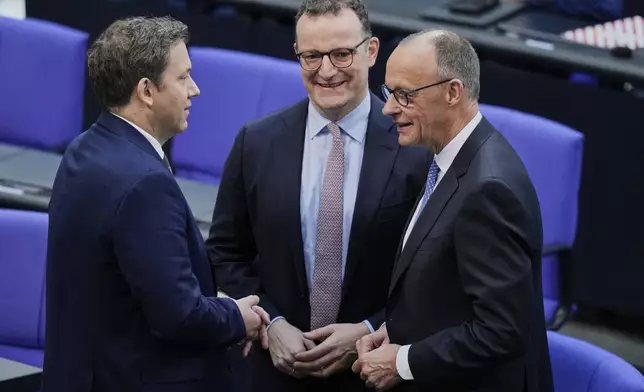Friedrich Merz, right, CDU faction leader Jens Spahn, centre and SPD leader Lars Klingbeil stand together n the parliament Bundestag in Berlin, Tuesday, May 6, 2025. (AP Photo/Ebrahim Noroozi)