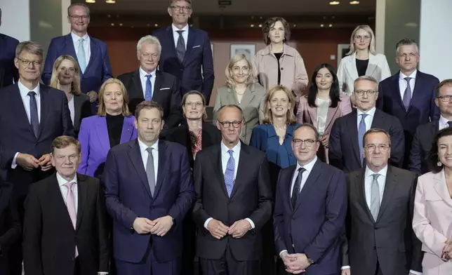 Newly-elected German Chancellor Friedrich Merz, center, and members of the new cabinet pose for a group photo after the first government cabinet meeting, at the chancellery in Berlin, late Tuesday, May 6, 2025. (AP Photo/Ebrahim Noroozi)