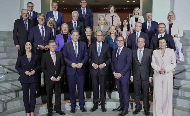 Newly-elected German Chancellor Friedrich Merz, center, and members of the new cabinet pose for a group photo after the first government cabinet meeting, at the chancellery in Berlin, late Tuesday, May 6, 2025. (AP Photo/Ebrahim Noroozi)
