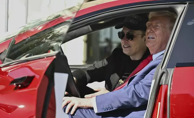 FILE - President Donald Trump and Tesla CEO Elon Musk speak to reporters as they sit in a red Model S Tesla vehicle on the South Lawn of the White House, March 11, 2025, in Washington. (Pool via AP, File)