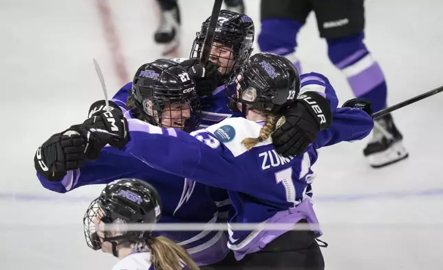 Minnesota Frost forward Taylor Heise (27), left, is surrounded by teammates, Minnesota Frost forward Britta Curl (77) and Minnesota Frost forward Grace Zumwinkle (13) after she scored the winning goal in overtime of the PWHL Walter Cup in St. Paul, Minn., on Wednesday, May 14, 2025. (Renée Jones Schneider/Star Tribune via AP)