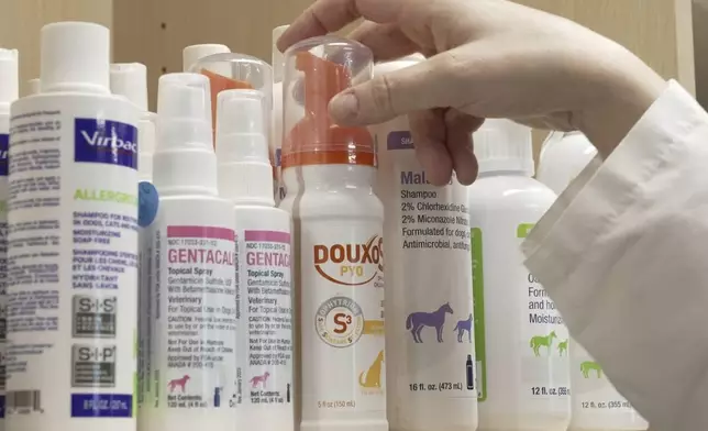 Various shampoos and cleansing products for treating allergies in pets sit on a shelf at Thrive Pet Healthcare in Elmhurst, Ill. on May 13, 2025. (AP Photo/Laura Bargfeld)