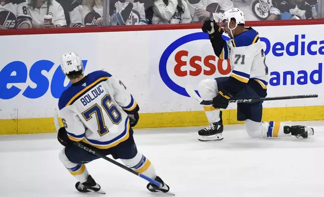 St. Louis Blues' Mathieu Joseph (71) celebrates after his goal against the Winnipeg Jets with Zack Bolduc (76) during the first period of Game 7 in an NHL hockey first-round playoff series in Winnipeg, Manitoba, Sunday, May 4, 2025. (Fred Greenslade/The Canadian Press via AP)