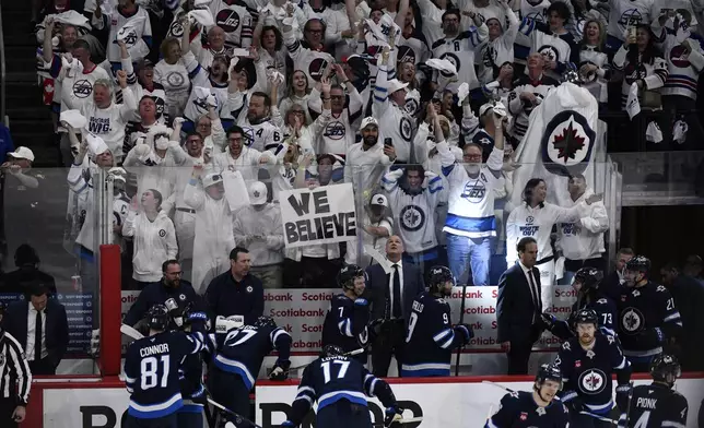 Winnipeg Jets fans celebrate after the team's third goal against the St. Louis Blues, during the third period of Game 7 in an NHL hockey first-round playoff series in Winnipeg, Manitoba, Sunday, May 4, 2025. (Fred Greenslade/The Canadian Press via AP)