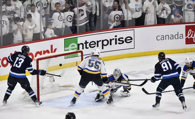 Winnipeg Jets' Cole Perfetti (91) scores against St. Louis Blues goaltender Jordan Binnington (50) during the third period of Game 7 in an NHL hockey first-round playoff series in Winnipeg, Manitoba, Sunday, May 4, 2025. (Fred Greenslade/The Canadian Press via AP)