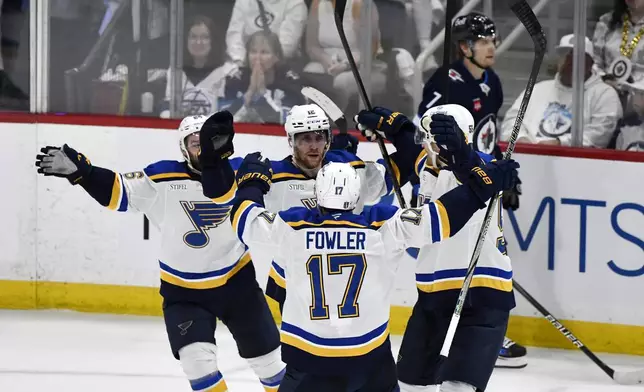 St. Louis Blues' Radek Faksa (12) celebrates after his goal against the Winnipeg Jets with Cam Fowler (17) during the second period of Game 7 in an NHL hockey first-round playoff series in Winnipeg, Manitoba, Sunday, May 4, 2025. (Fred Greenslade/The Canadian Press via AP)