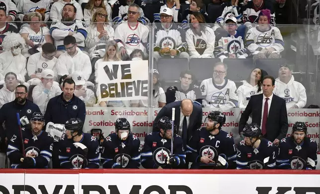 Winnipeg Jets players confer with coaches during a break in play against the St. Louis Blues during the first period of Game 7 in an NHL hockey first-round playoff series in Winnipeg, Manitoba, Sunday, May 4, 2025. (Fred Greenslade/The Canadian Press via AP)