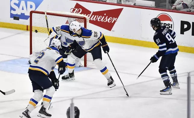 Winnipeg Jets' Cole Perfetti (91) scores against St. Louis Blues goaltender Jordan Binnington (50) during the second period of Game 7 in an NHL hockey first-round playoff series in Winnipeg, Manitoba, Sunday, May 4, 2025. (Fred Greenslade/The Canadian Press via AP)