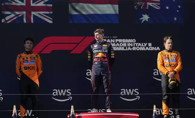 Red Bull driver Max Verstappen of the Netherlands celebrates on the podium after winning the Italian Emilia Romagna Formula One Grand Prix, flanked with McLaren driver Lando Norris of Britain, left, and McLaren driver Oscar Piastri of Australia, at the Enzo and Dino Ferrari racetrack in Imola, Italy, Sunday, May 18, 2025. (AP Photo/Luca Bruno)